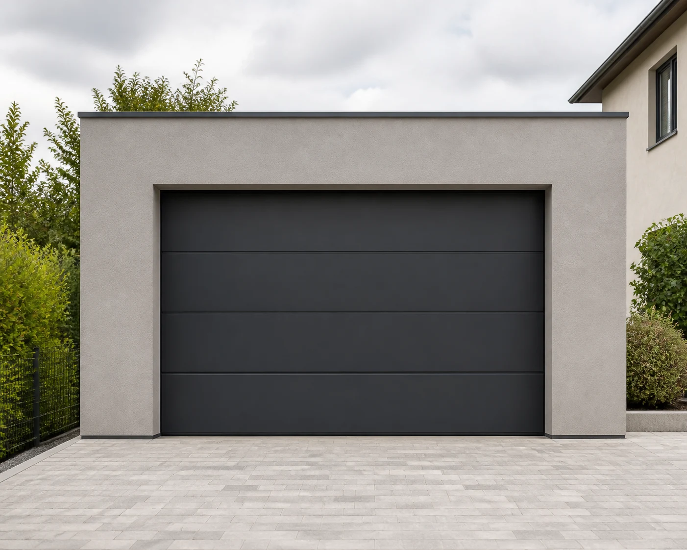 Moderne Fertiggarage neben einem Wohnhaus mit gepflasterter Zufahrt
